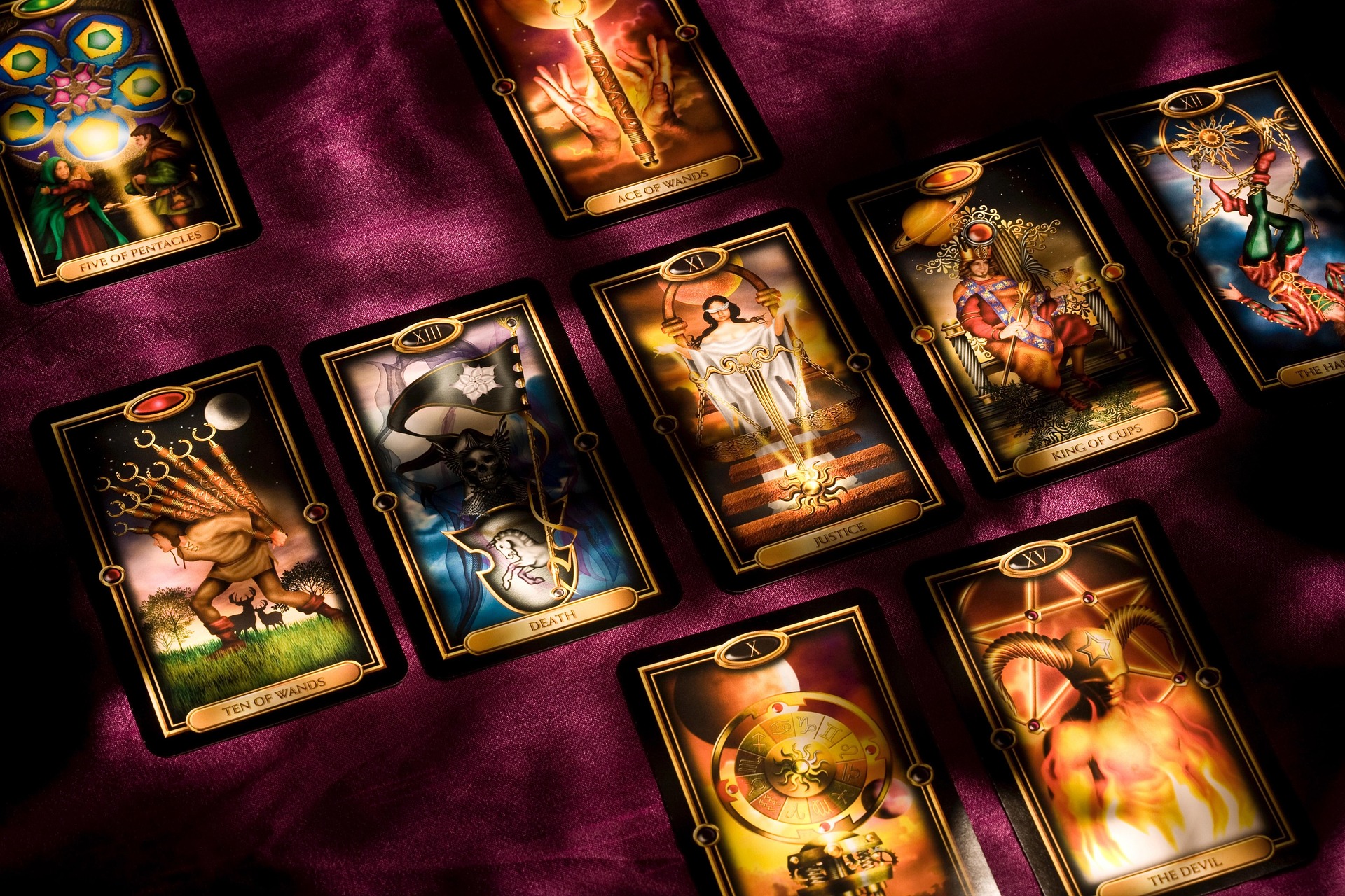 A spread of tarot cards on deep plum fabric